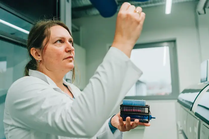 Eine Frau hält Probe hoch zur Kontrolle