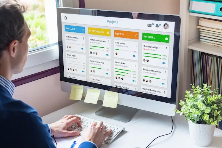 Manager working with agile product development using scrum or kanban methodology, lean project management framework with iterative or incremental strategy, person with computer in office.